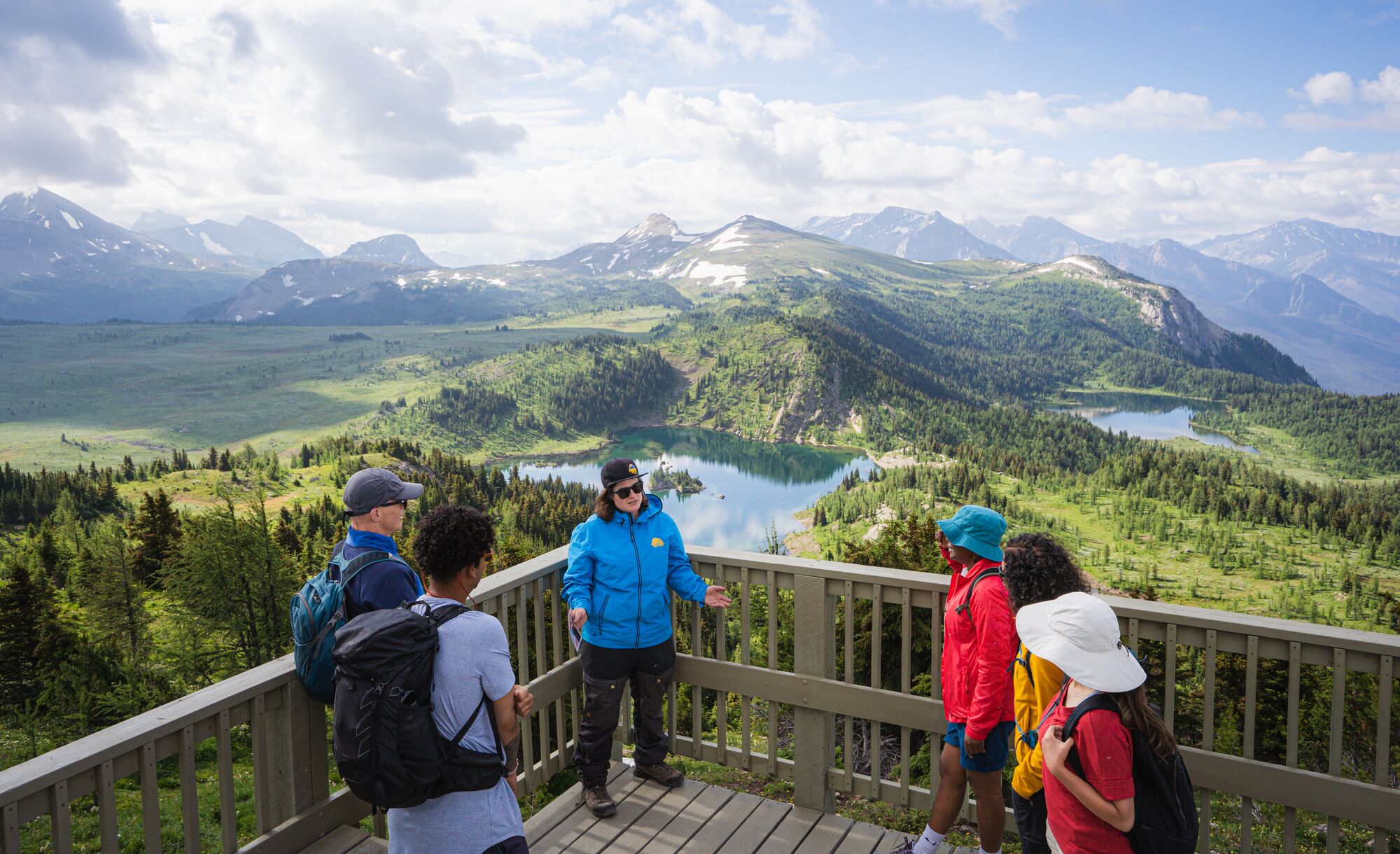 A hiking guide at Sunshine Meadows talks to a group of people at the Standish Lookout viewpoint.